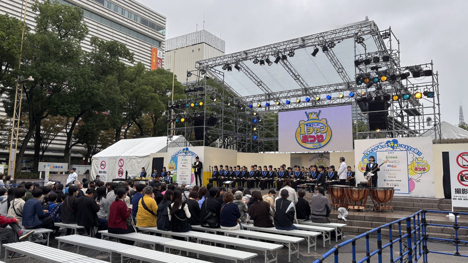 屋外イベントのメインステージと、客席に集まった来場者
